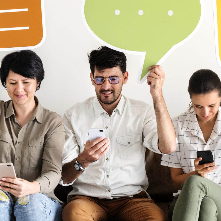 Co-workers sitting on couch and holding message icons